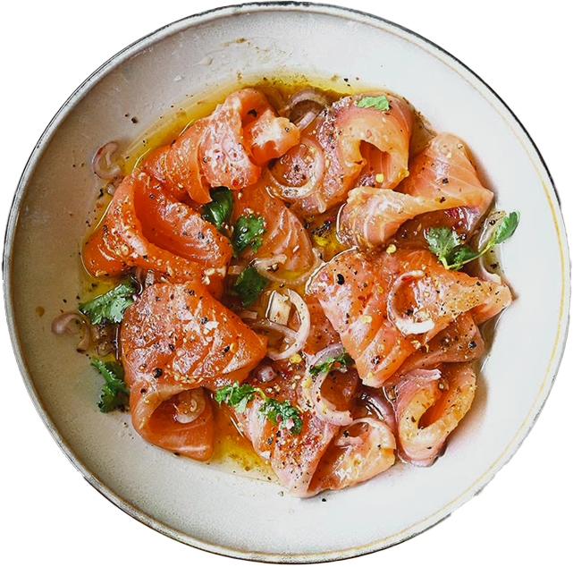 A ceramic plate of cured salmon with herbs and shallots